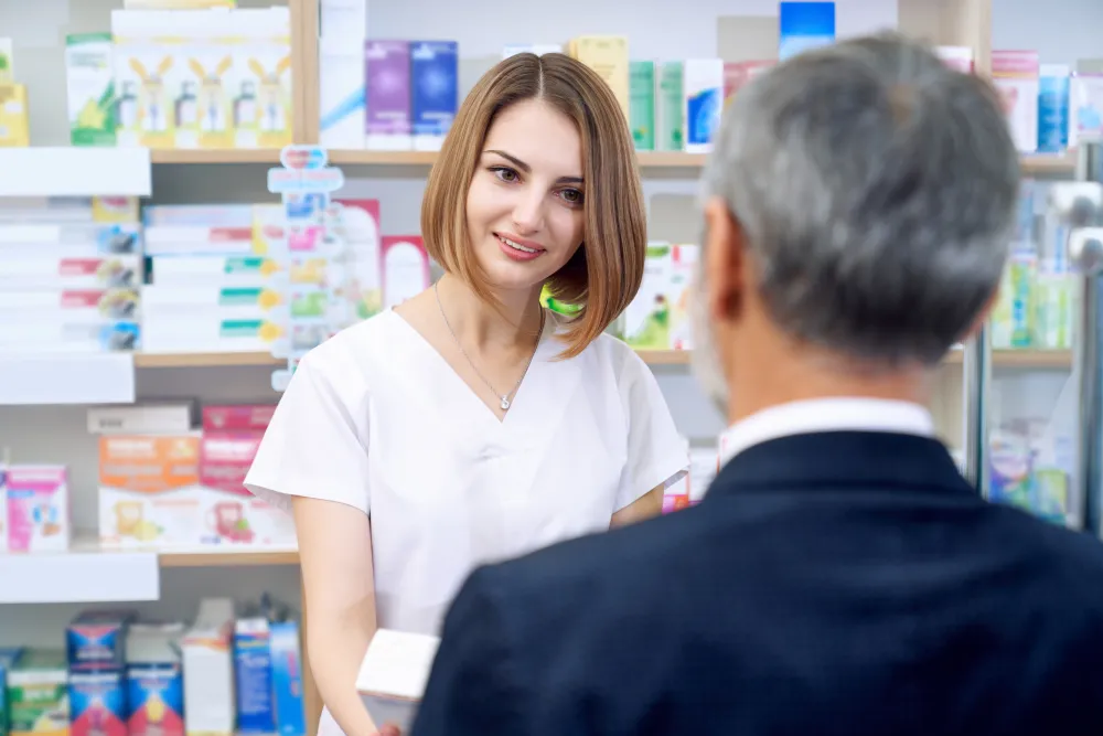 Apothekerin berät eine Kundin am Verkaufstresen