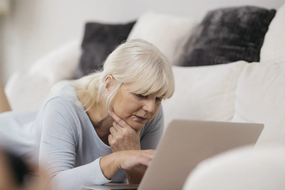 Frau sitzt nachdenklich vor ihrem Laptop