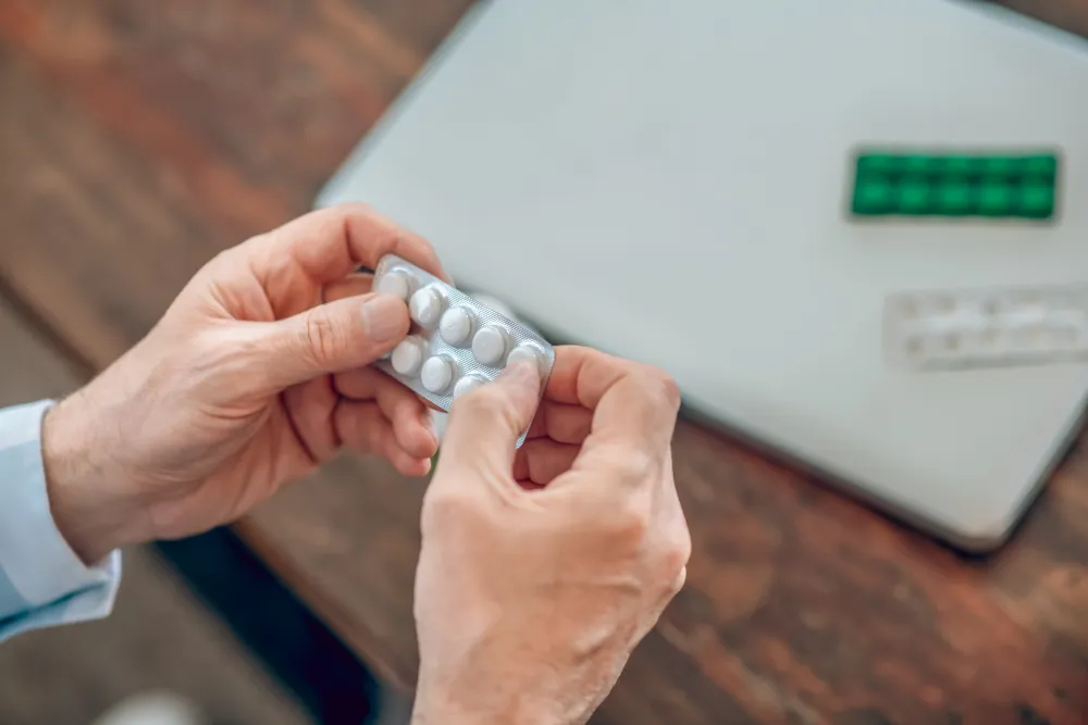 Hände halten eine Blisterpackung mit weißen Tabletten